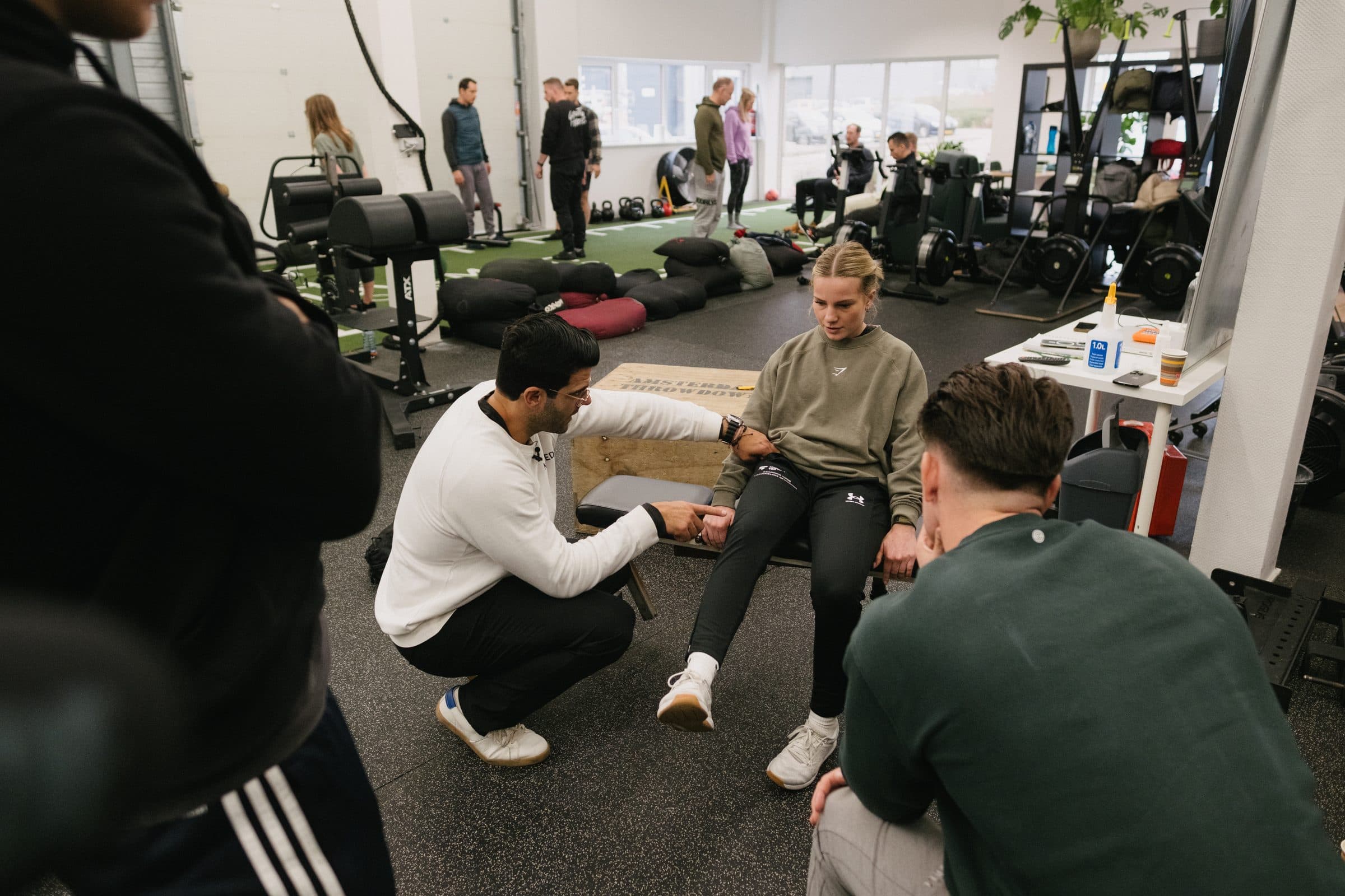 Richard Aceves demonstrating hands-on ankle mobility work in front of a group