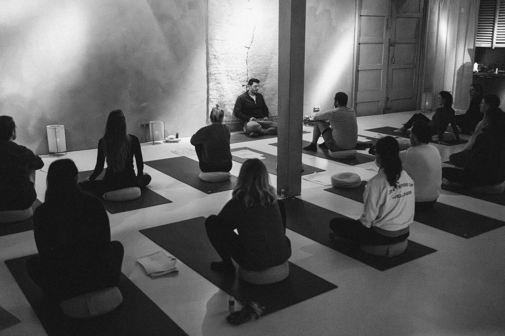 A seated circle of SWAMI participants facing Richard Aceves in a quietly lit studio
