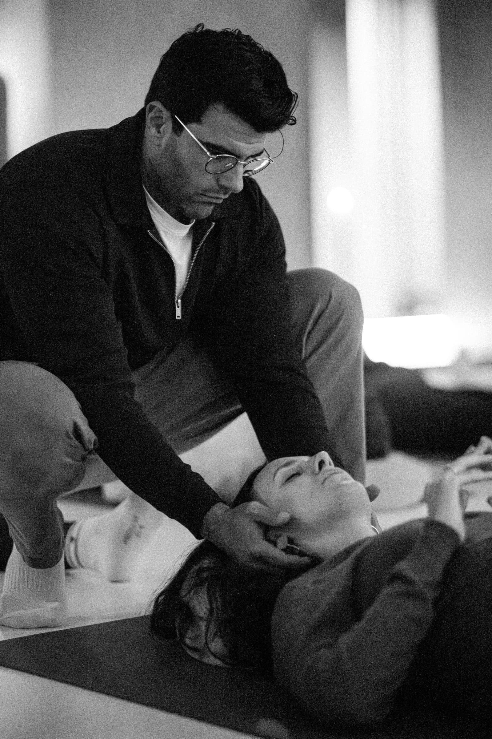Richard Aceves gently guiding a participant's head during a breathwork session