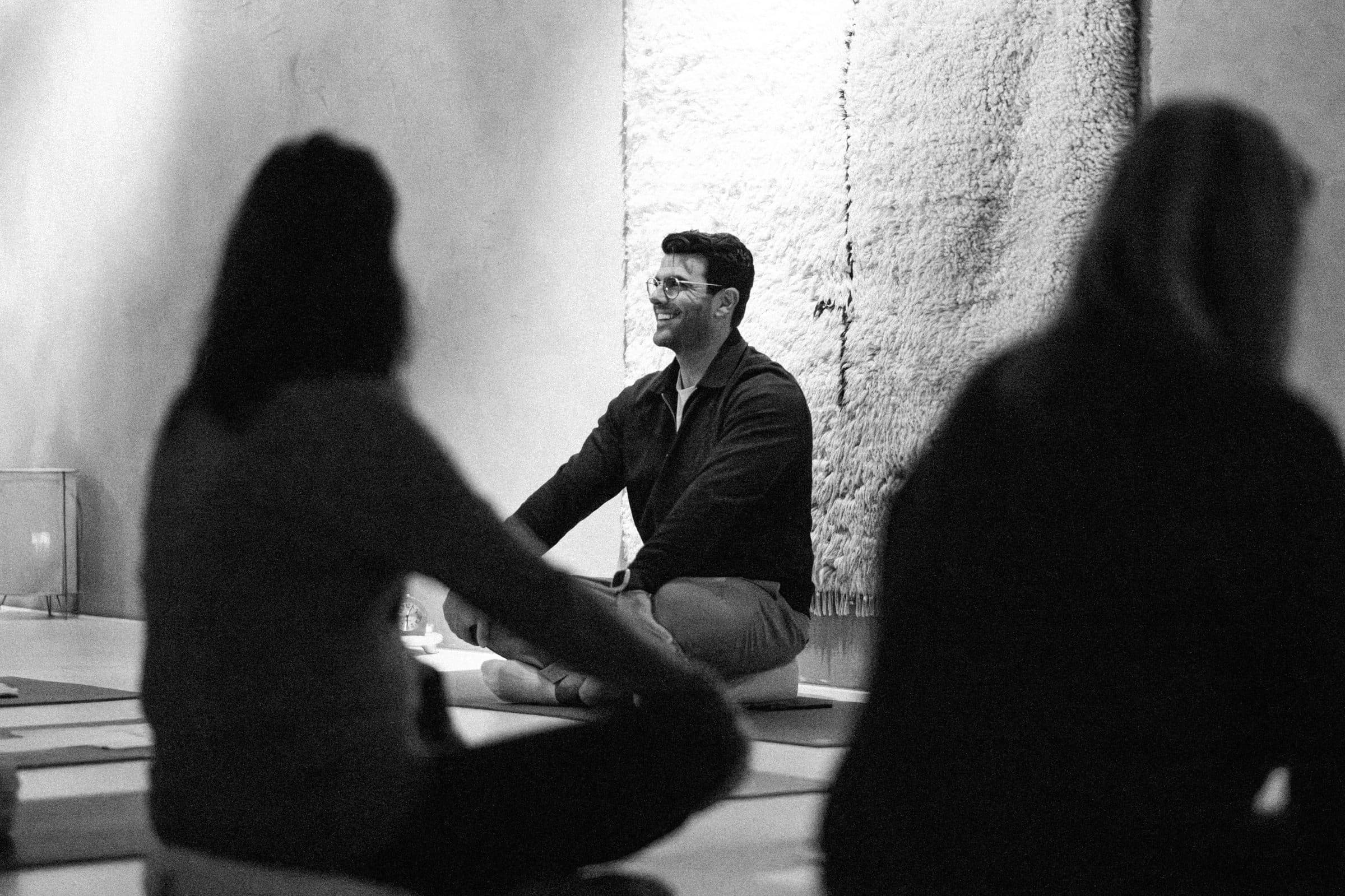 Richard Aceves seated cross-legged, teaching a small seated group
