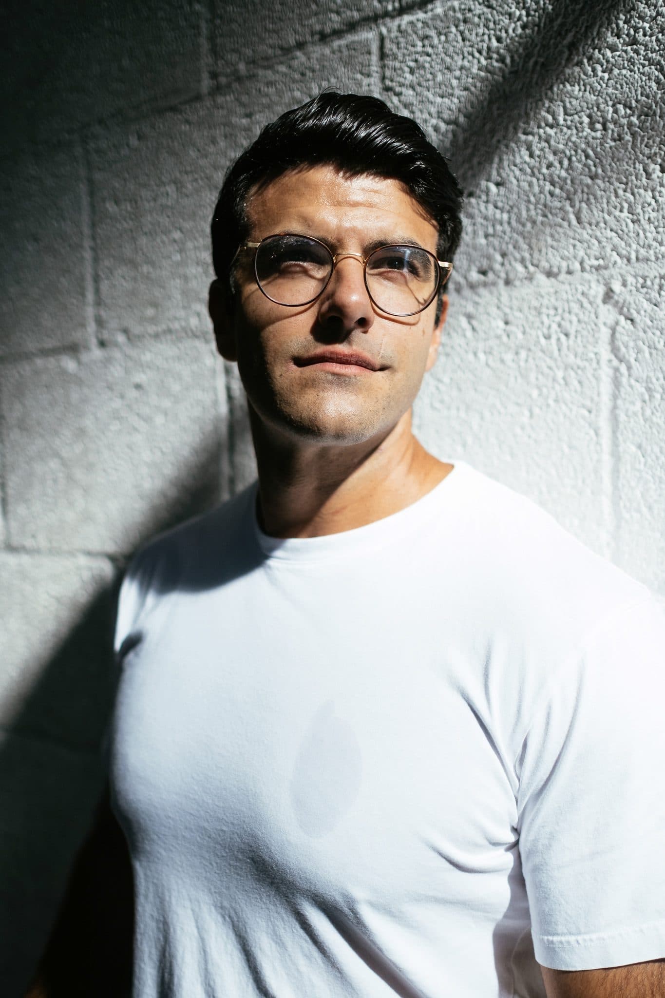Richard Aceves in dramatic side light against a concrete wall