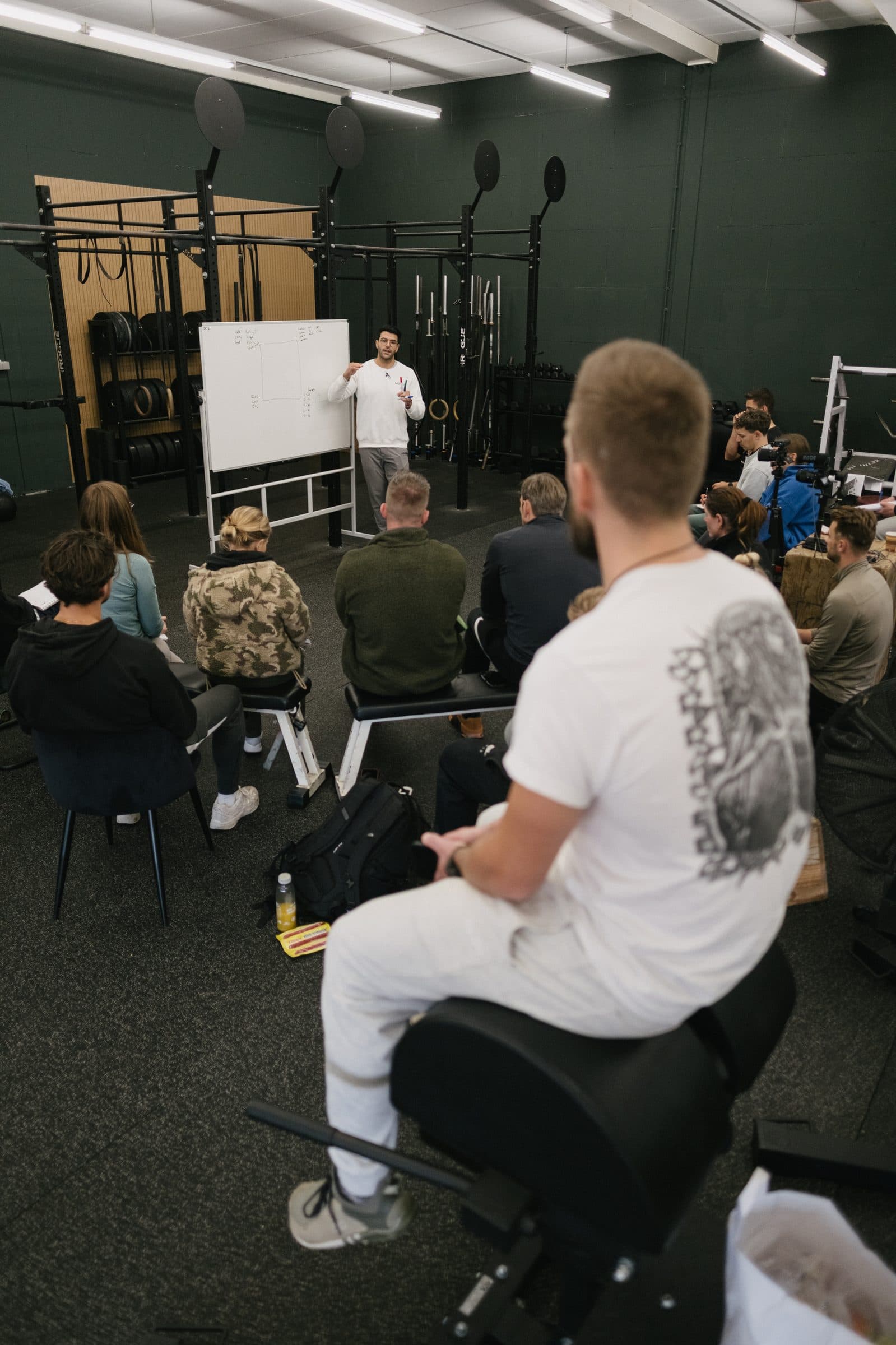 View from behind a seated audience toward Richard Aceves teaching at a whiteboard